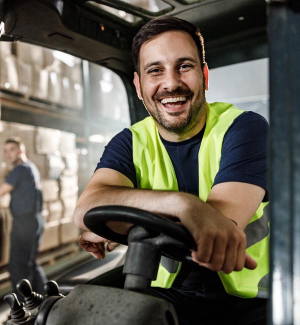 smiling man driving forklift